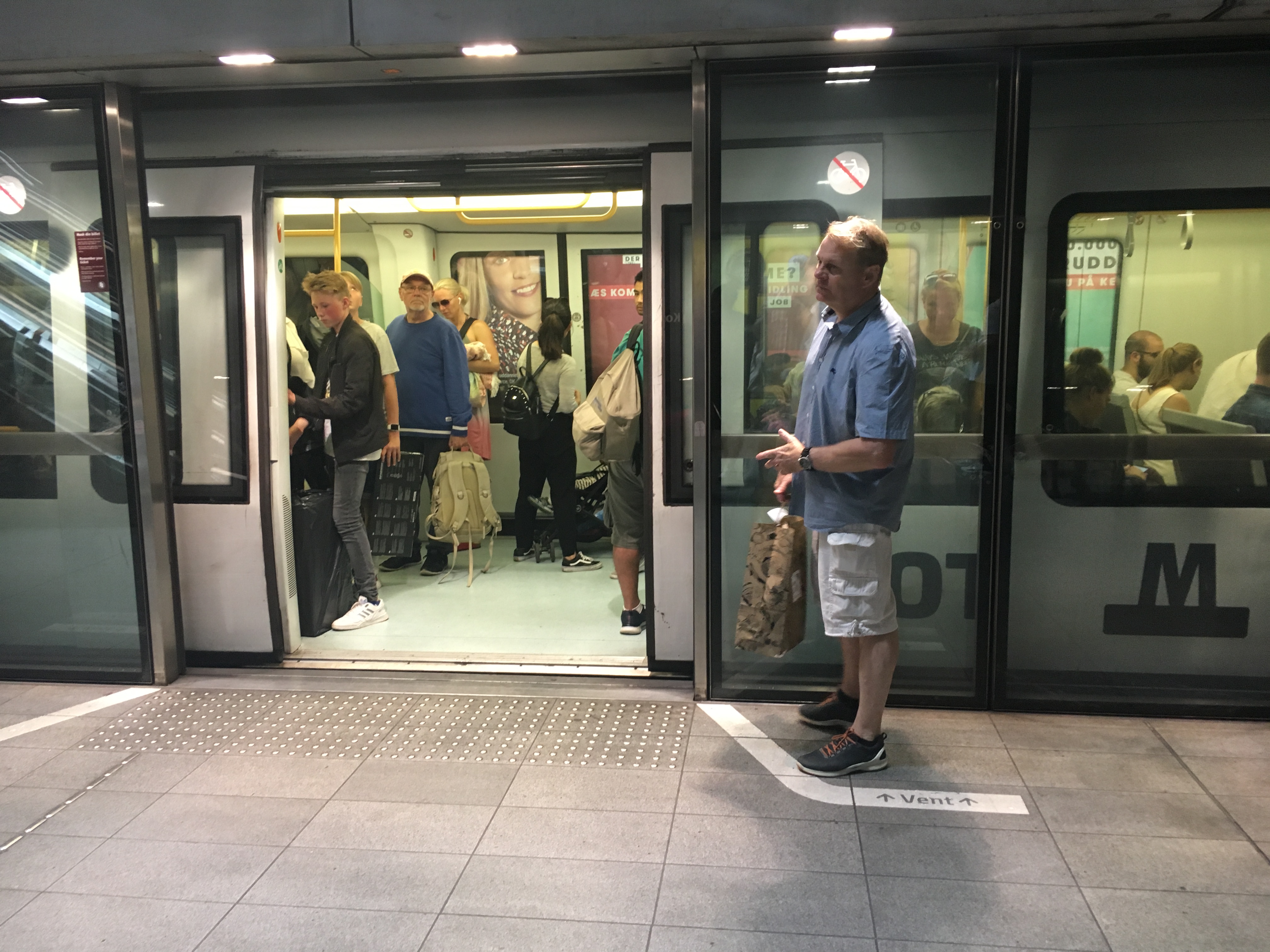 A man stands in a waiting area designed into the subway at Copenhagen. Notice the large wall of sliding doors. Ontario Line could use a similar staging areas and barriers, making boarding and offloading faster